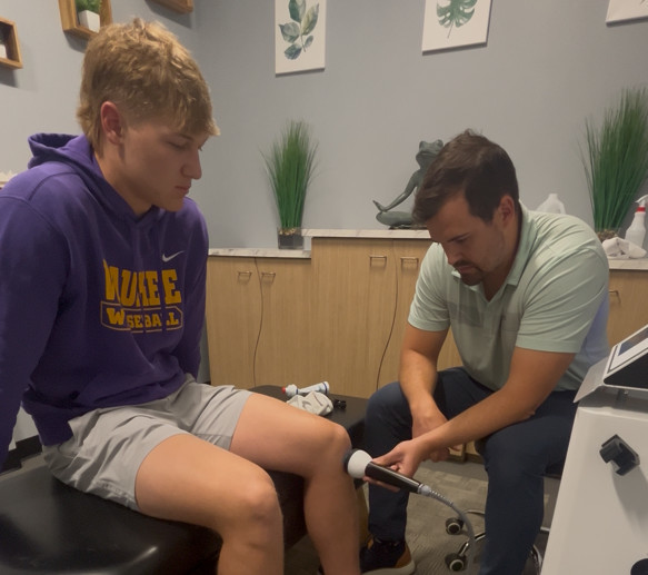 A chiropractor in Waukee adjusts an athlete's spine in a modern clinic, helping them recover from a sports injury to get back in the game.