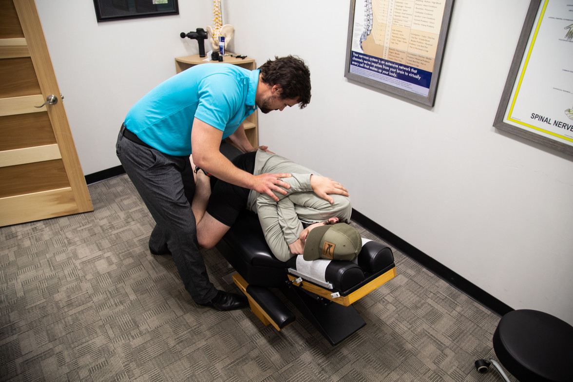 Back pain chiropractor Waukee performing gentle spinal adjustment on patient for lower back pain relief